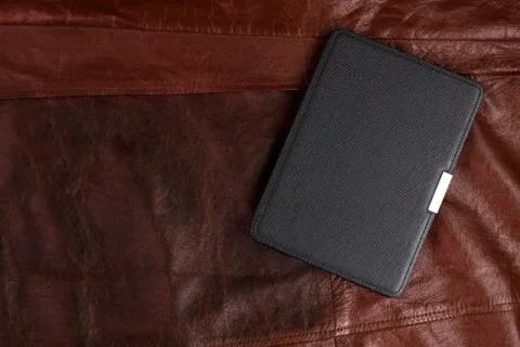 Electronic book in the case on leather background Stock Photos