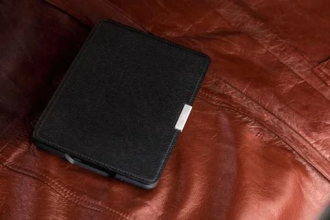 Electronic book in the case on leather background Stock Photos