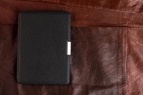 Electronic book in the case on leather background Stock Photos