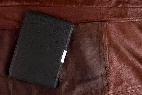 Electronic book in the case on leather background Stock Photos