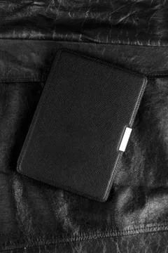 Electronic book in the case on leather background Stock Photos
