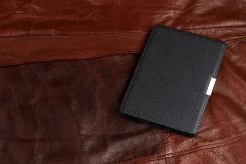 Electronic book in the case on leather background Stock Photos