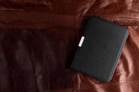 Electronic book in the case on leather background Stock Photos