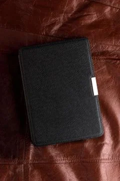 Electronic book in the case on leather background Stock Photos