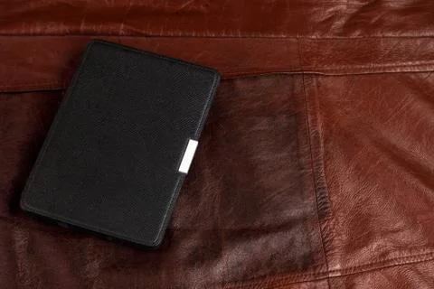 Electronic book in the case on leather background Stock Photos