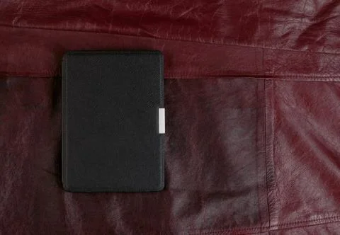 Electronic book in the case on leather background Stock Photos