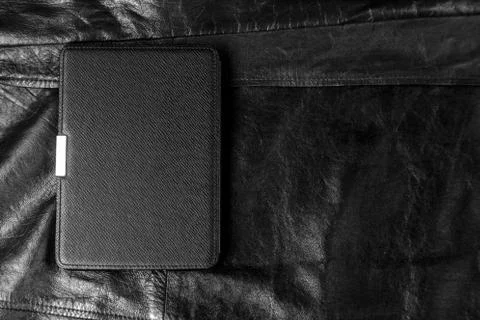 Electronic book in the case on leather background Stock Photos