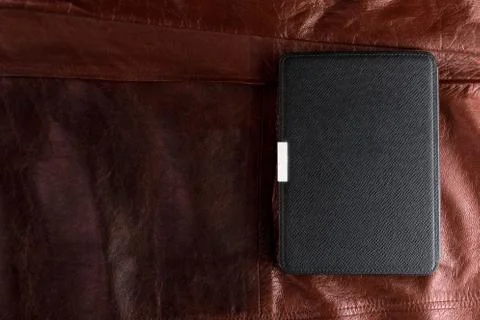 Electronic book in the case on leather background Stock Photos