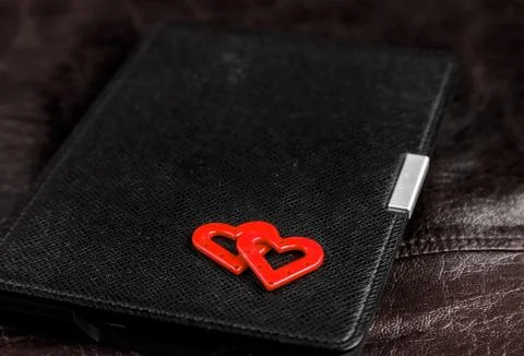 Electronic book in case with two hearts on leather background. Romantic book  Foto stock