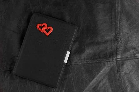 Electronic book in case with two hearts on leather background. Romantic book  Foto stock