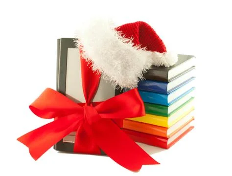 Electronic book reader wearing santa's hat with stack of books Stock Photos