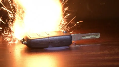 An electronic car key lies on a table, bright sparks shooting out of it, symboli Stock Footage 309484807