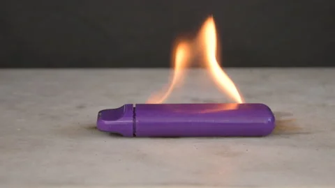 The electronic cigarette burns with a bright flame and sparks fly on a dark back Stock Footage 232330405