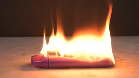 An electronic cigarette burns with fire and melts on a dark background. A short  Video stock 232330183
