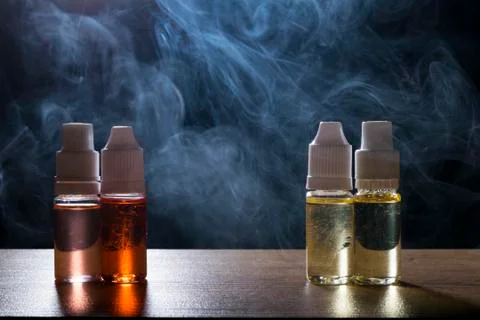 Electronic cigarette, vaping device with e liquid background. Stock Photos