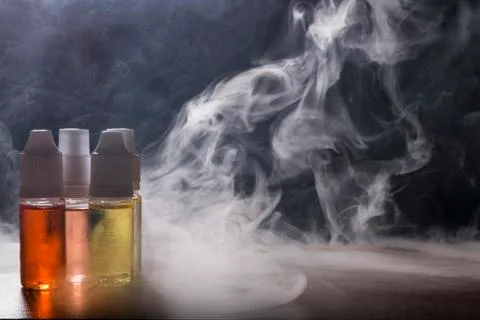 Electronic cigarette, vaping device with e liquid background. Stock Photos
