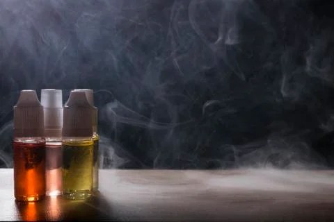 Electronic cigarette, vaping device with e liquid background. Stock Photos