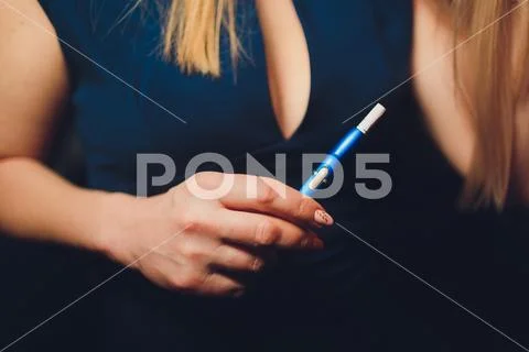 Electronic cigarettes, technology cigarette. Tobacco system IQOS. Female hand on Stock Photos
