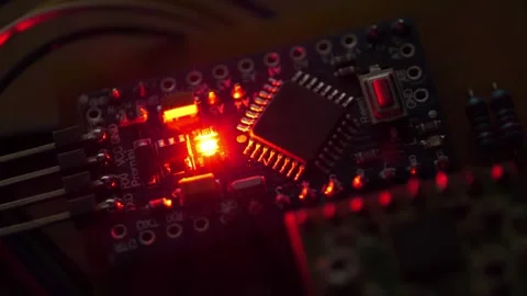 Electronic circuit with burning red LED light bulb in the darkness. Microcircuit Stock Footage 278218700