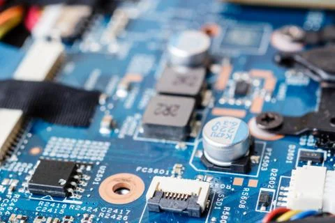 Electronic components, chips and capacitors on the blue pcb, close up view Stock Photos