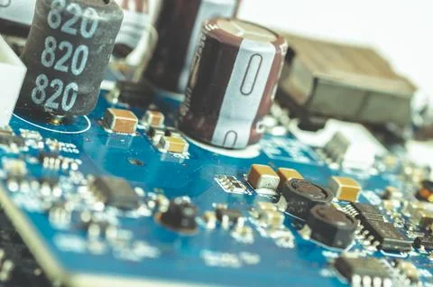 Electronic components, chips and capacitors on the blue pcb, close up view... Stock Photos