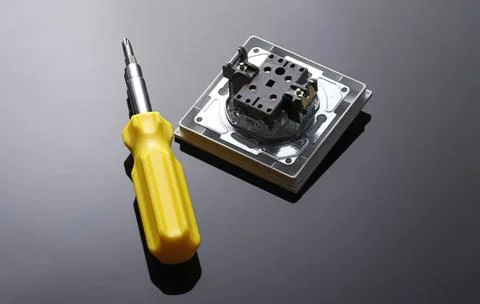 Electronic device being repaired with screwdriver and parts Stock Photos
