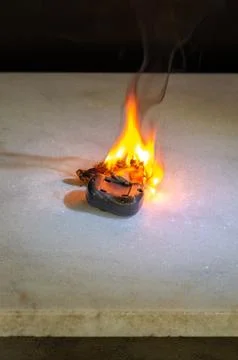 Electronic device burning on surface with flame as danger and risk concept Stock-Fotos