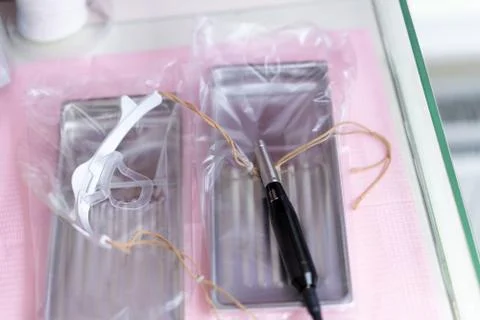 Electronic device for permanent make-up lies in a metal bath with an oversize Foto stock