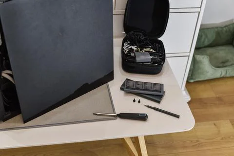 Electronic device with side panel open on table with repair tools Foto stock
