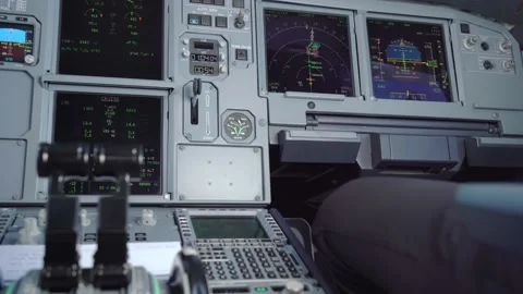 An electronic flight control panel with relaxing copilot leg in his station seat Stock Footage 166543043