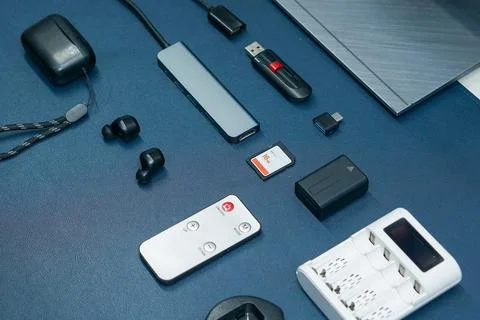 Electronic gadgets and computer accessories laid out on a dark desk Stock Photos