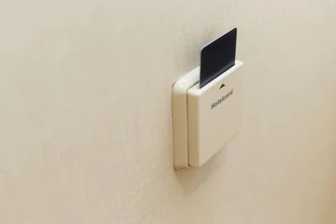 Electronic lock with card inserted and light switches on wall in hotel room Stock Photos