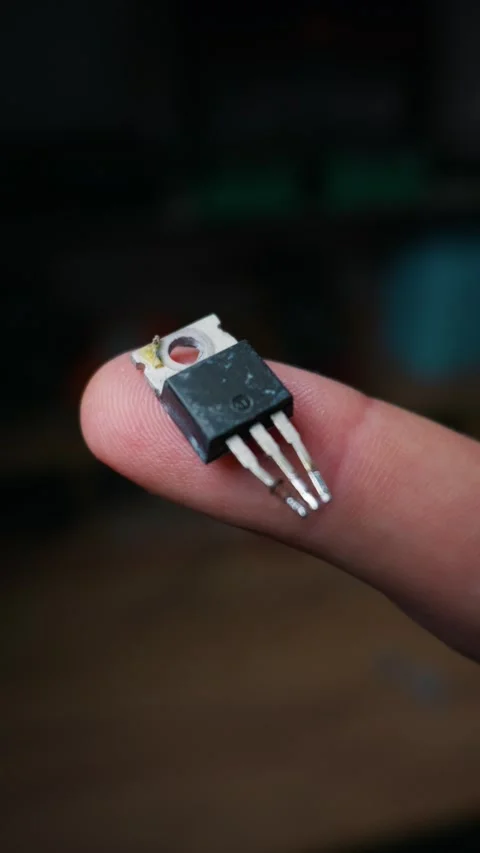 Electronic Power Transistor Semiconductor Component Held on Human Finger Tip Stock Footage 339364895