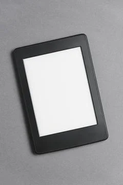 Electronic reader with blank screen on a grey background. Concept of technology Stock Photos