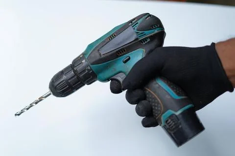 Electronic rechargeable drill in hand on white background. closeup image Stock Photos