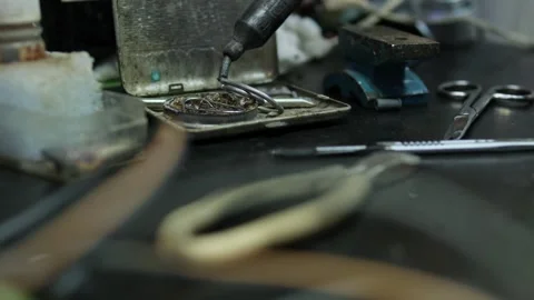 Electronic repair technician using a soldering iron on a circuit board, with Stock Footage 300551040