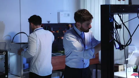 Electronic specialist worker fixing problem on 3d printer. His asian cheerful Stock Footage 153745117