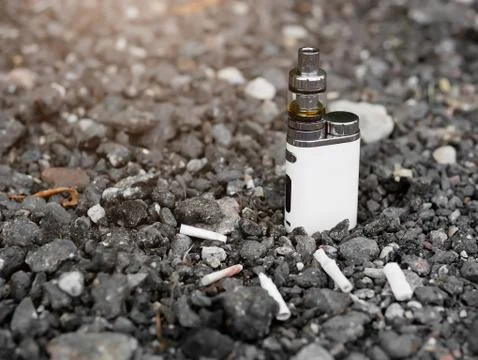 Electronic steam generator on the background of cigarette butts Stock Photos