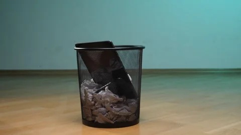 Electronic tablet device and crumpled paper trash filling a black mesh Stock Footage 342768678