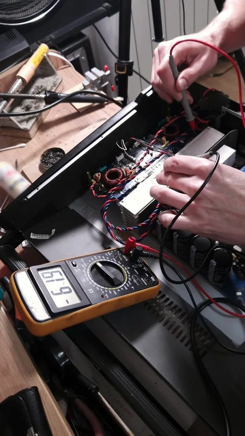 Electronic Technician Repairing Audio Amplifier Circuit Board with Multimeter Stock Footage 339001762