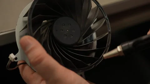 Electronic technician using compressed air to clean dust from console cooling Stock Footage 306895120