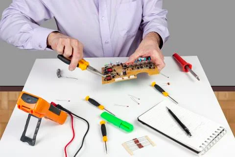 Electronic test engineer using long nose pliers mount component in a circuit Stock Photos