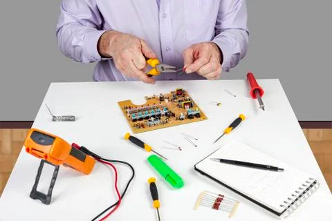 Electronic test engineer using long nose pliers to form a circuit componant Stock Photos