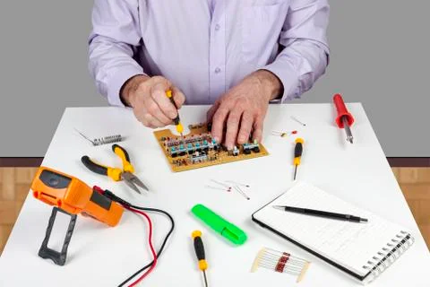 Electronic test engineer using a screwdriver to mount a circuit board switch Stock Photos