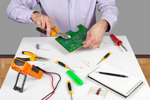 Electronic test engineer using side cutters to trim a soldered componant Stock Photos