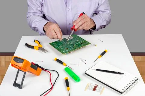 Electronic test engineer using a soldering iron on a printed circuit board Stock Photos