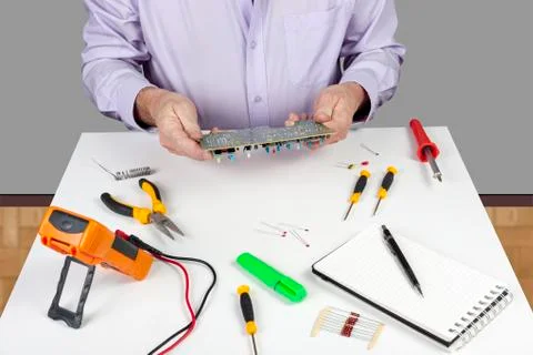 Electronic test engineer visually inspecting a faulty printed circuit board Foto stock