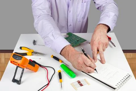Electronic test engineer writing his circuit testing results in a note pad Stock Photos
