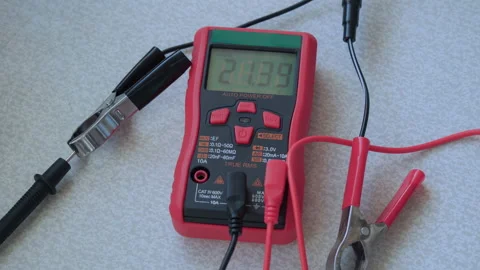 Electronic tester with changing voltage readings on a digital screen. Stock Footage 228824505