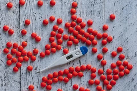 An electronic thermometer with a high temperature mark of 39.7 among many bri Stock Photos